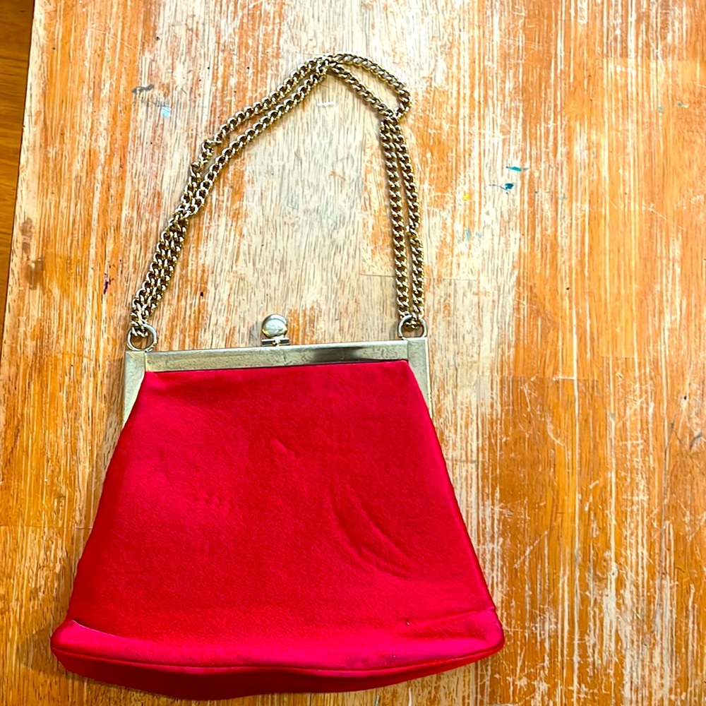 Red silk clutch. A few scuff marks along the bottom of the purse.